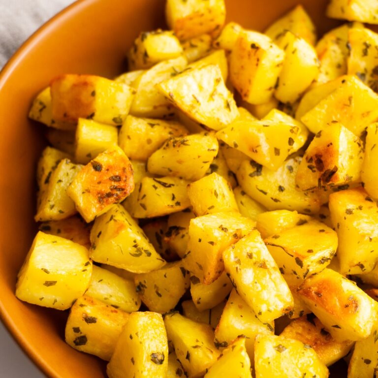 Close up of crispy roasted potatoes in a bowl.
