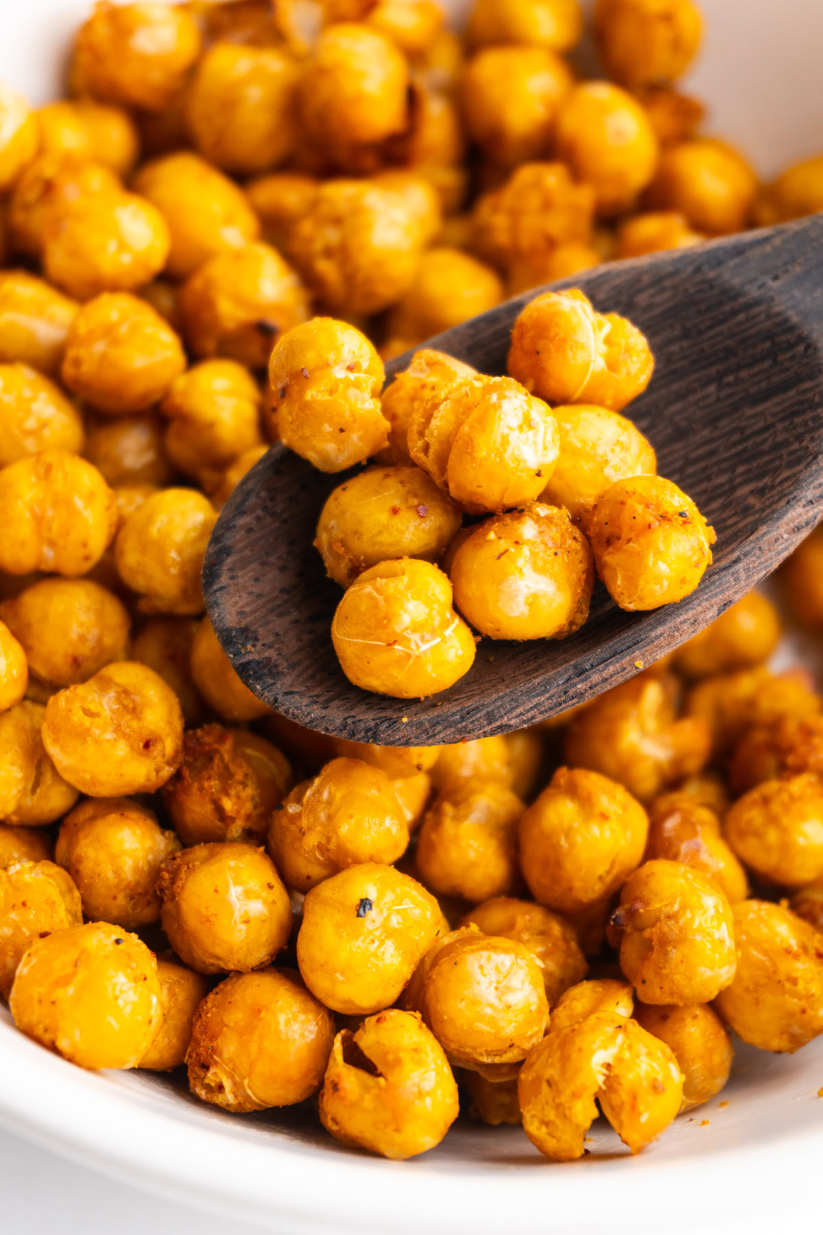 Close up of crispy air fryer chickpeas in a wooden spoon.