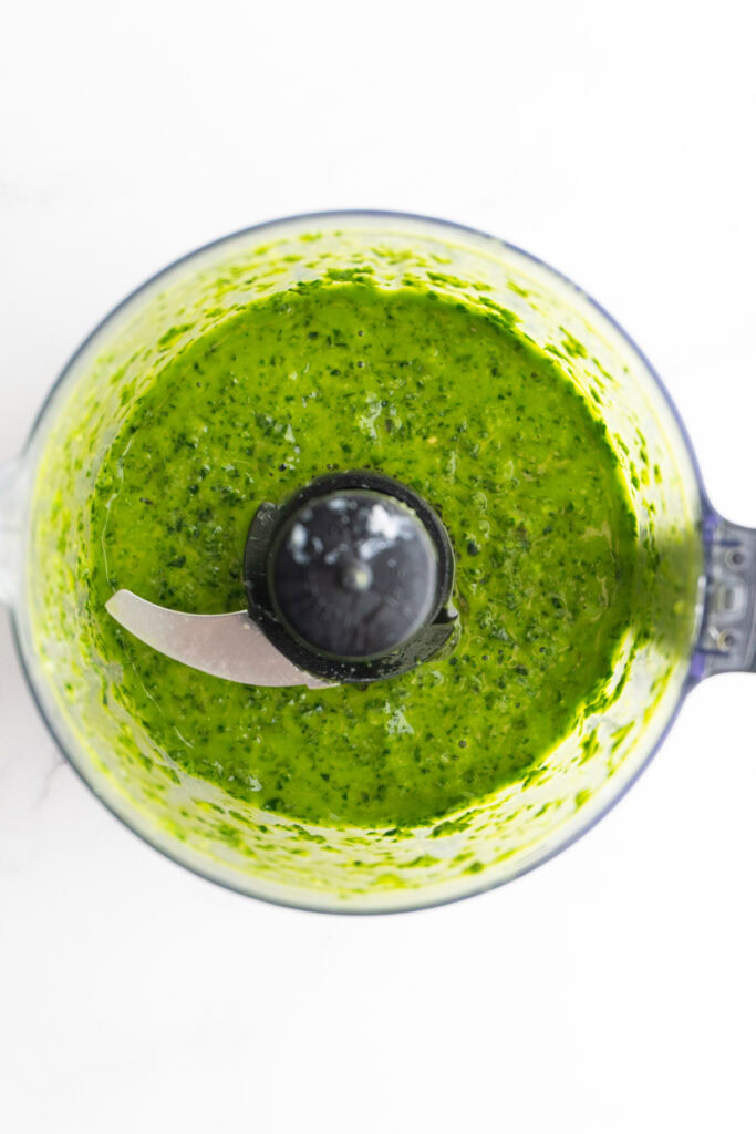 Pesto sauce in the food processor after blending.