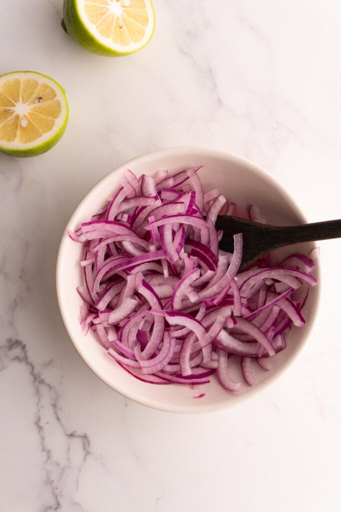 Pickled onions in a bowl after just mixing with lime and salt.