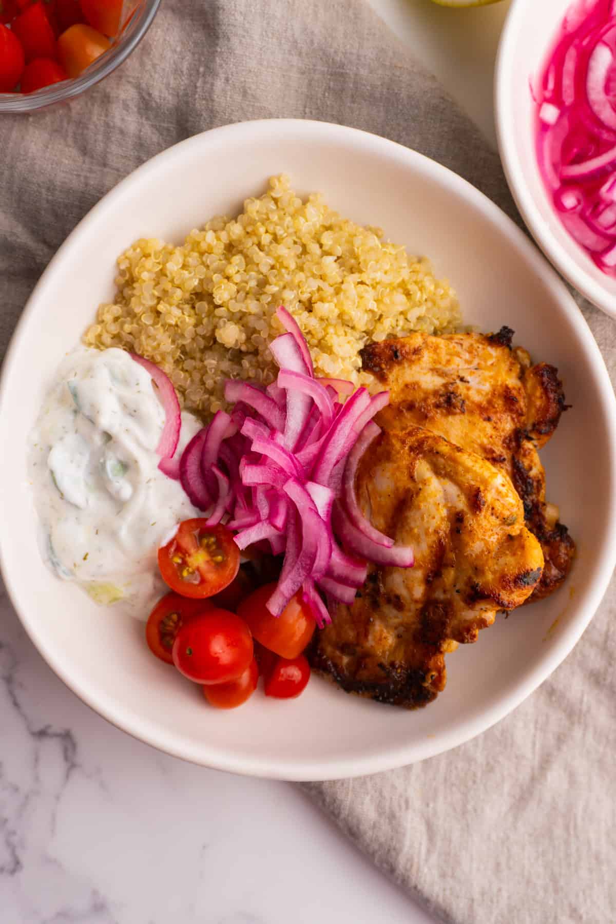 Mediterranean chicken quinoa bowl in a white bowl.
