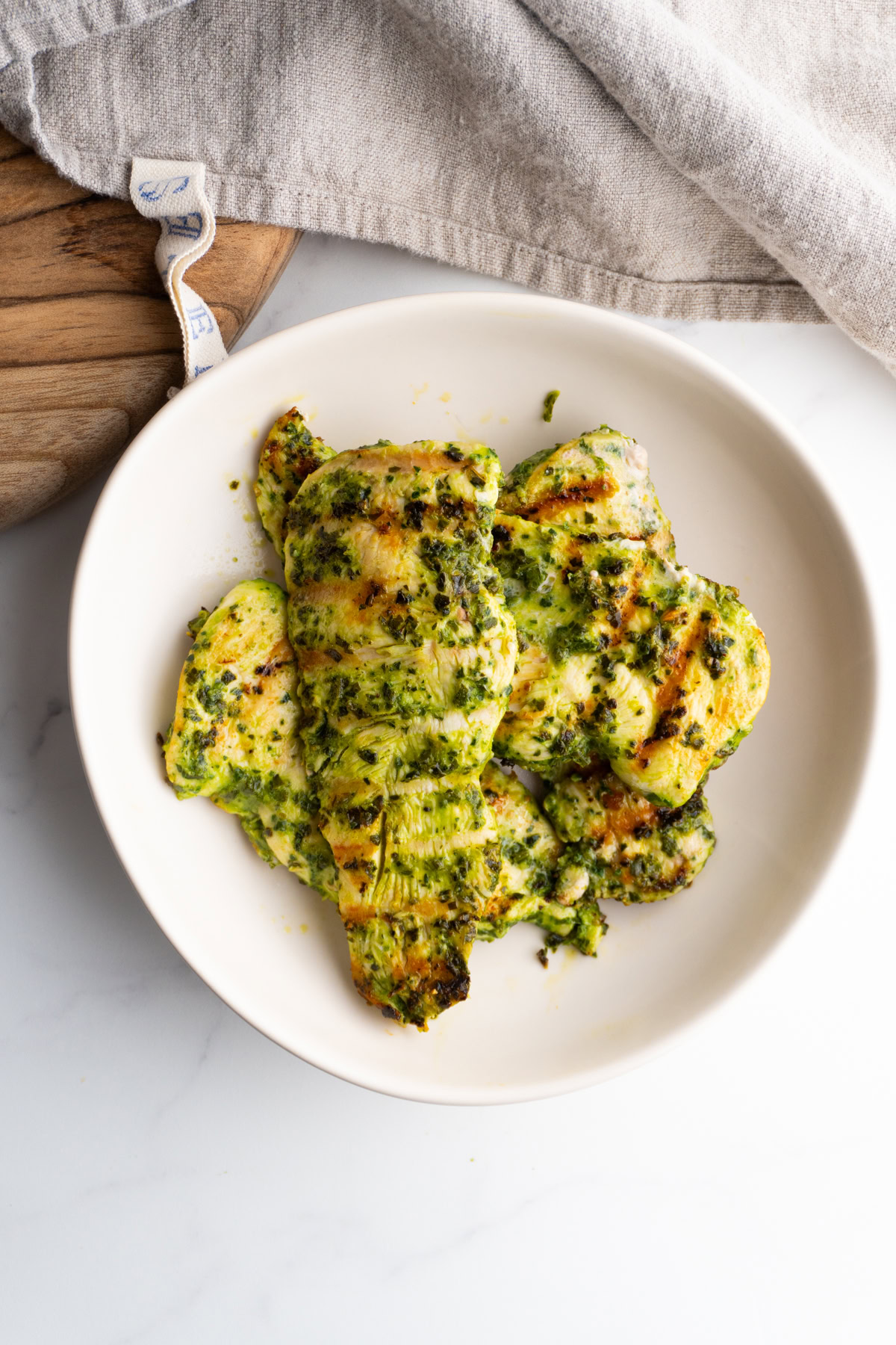 Pesto marinated chicken breasts served in a bowl.