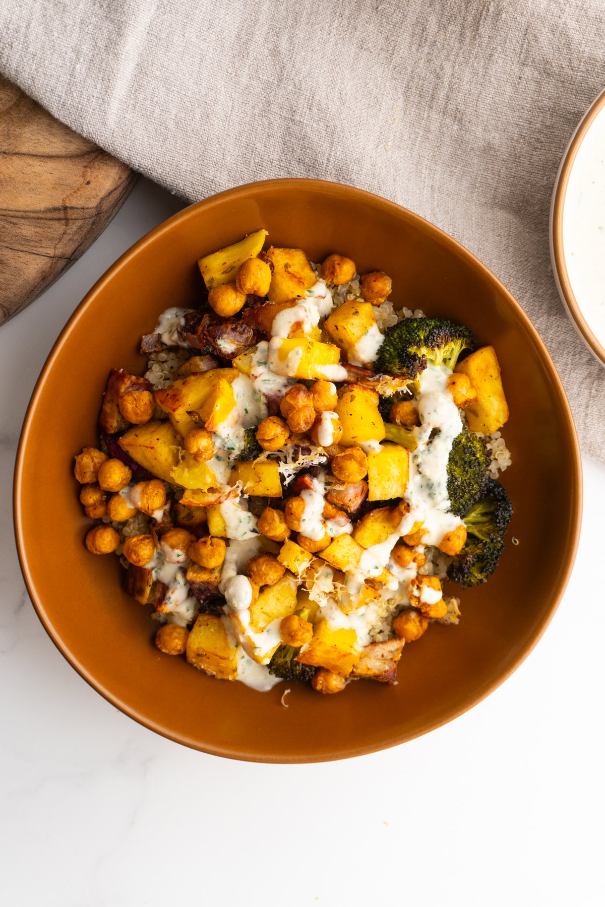 Overhead shot of a roasted vegetables grain bowl in a clay bowl.