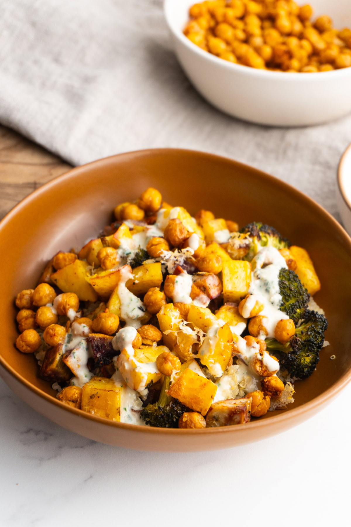 Side view of roasted veggie bowl in a brown bowl.