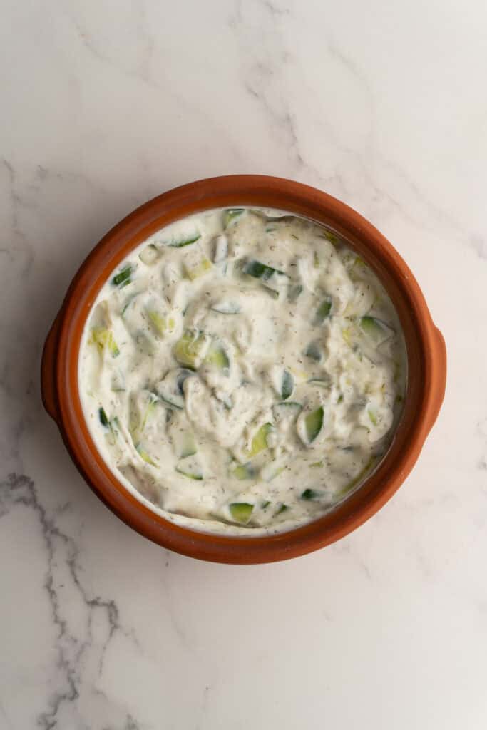 Tzatziki sauce in a bowl after being mixed together.