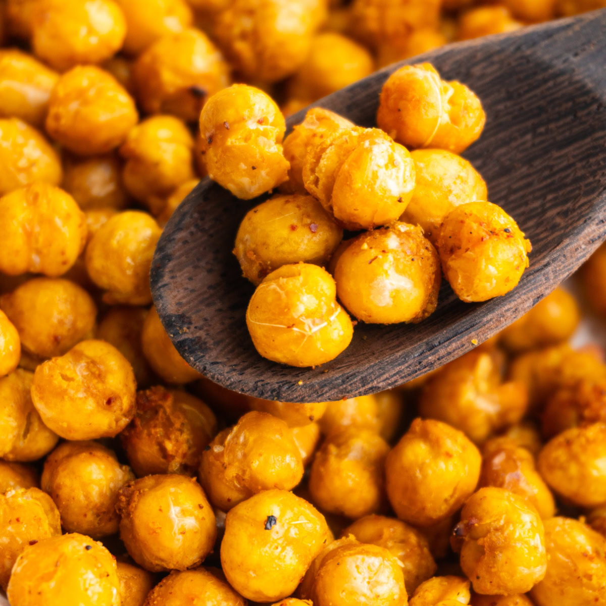 Close up of crispy air fryer chickpeas on a wooden spoon.