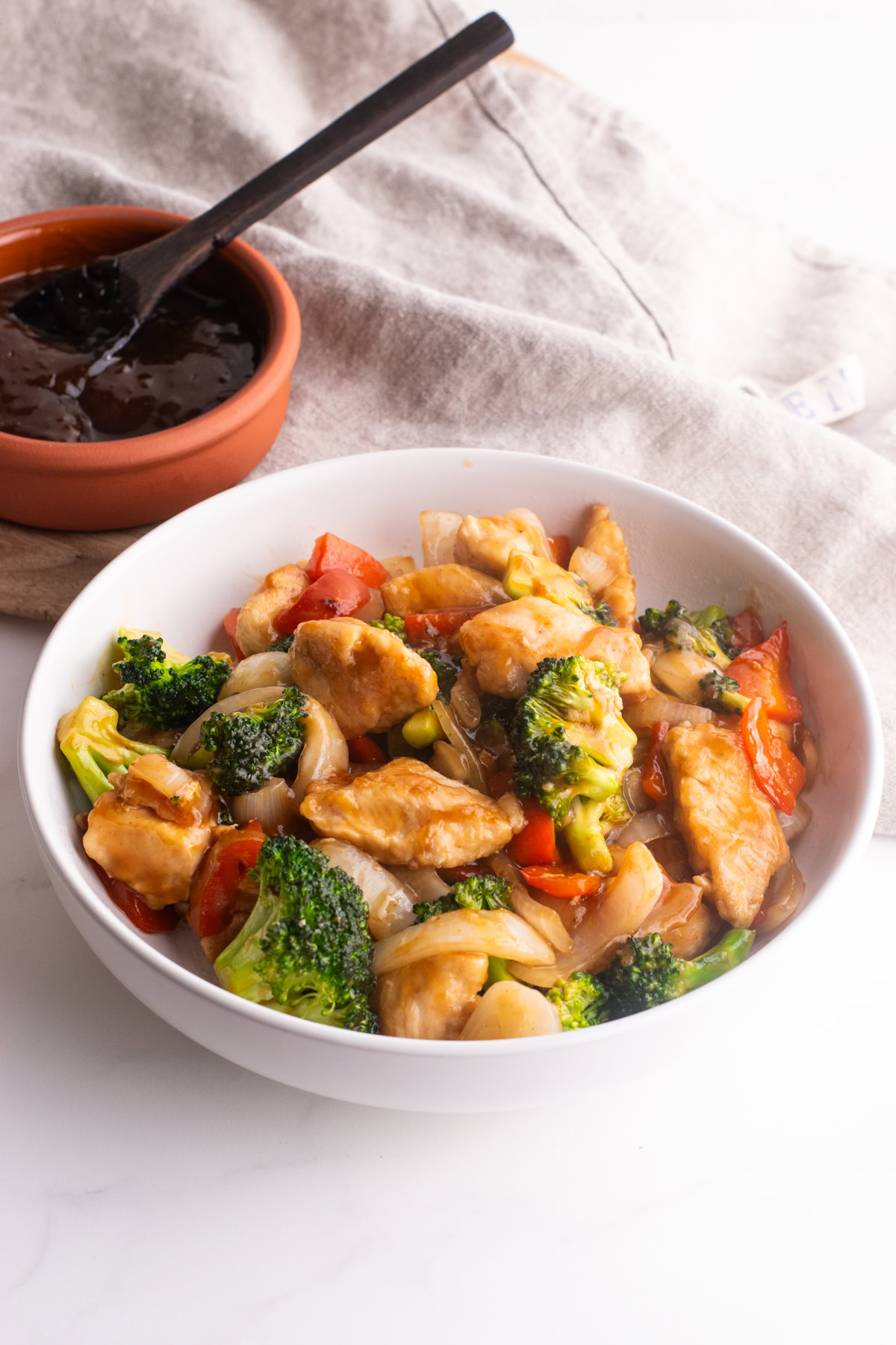 Chicken and vegetable stir fry in a white bowl.