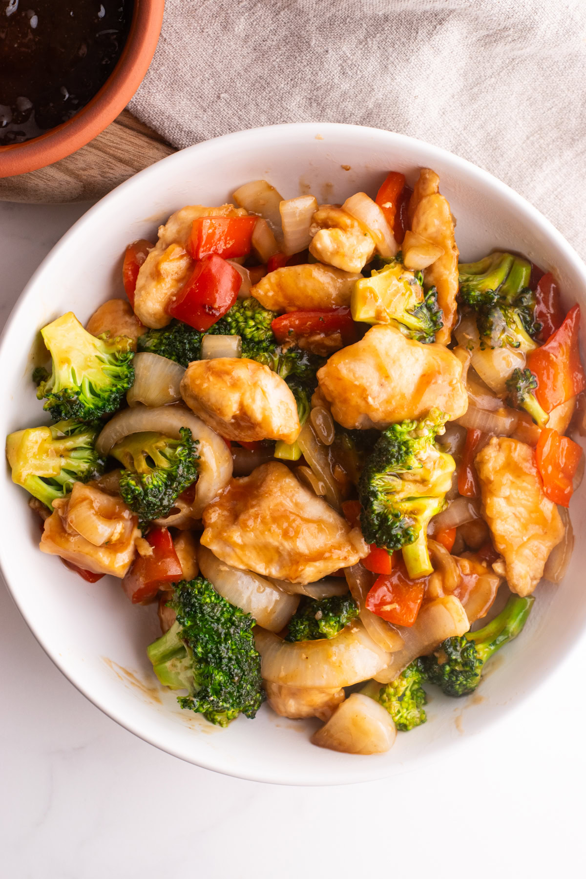 Chicken teriyaki stir fry in a white bowl.