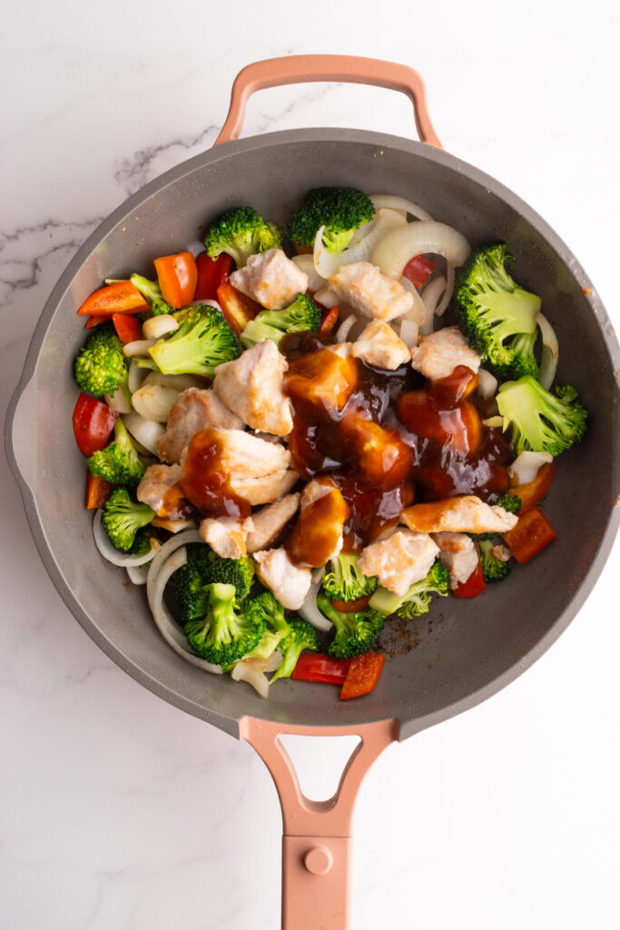 Chicken and broccoli stir fry in a skillet.