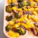 Side view of parmesan roasted vegetables on a roasting pan.