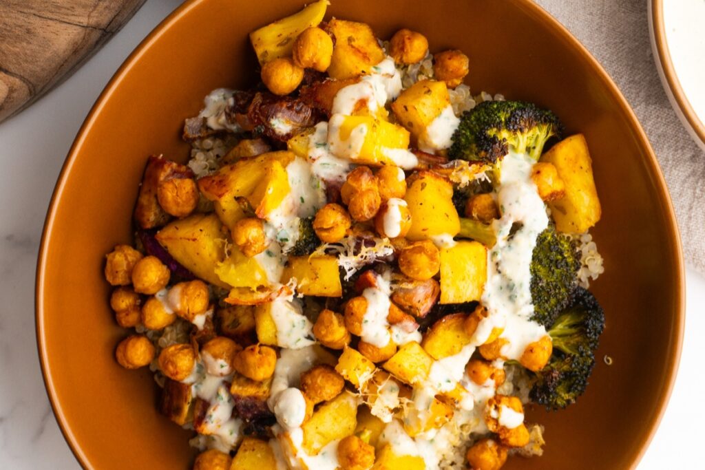 Close up of roasted veggie bowl, drizzled with lemon tahini.