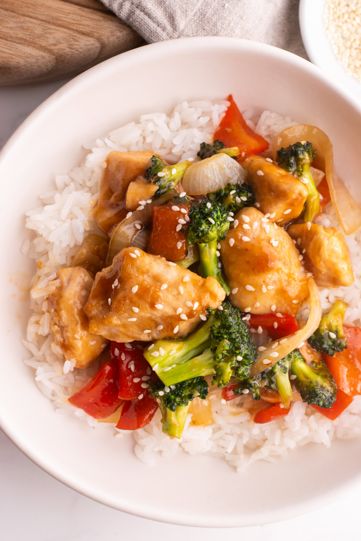 Close up of a teriyaki chicken bowl garnished with sesame seeds.