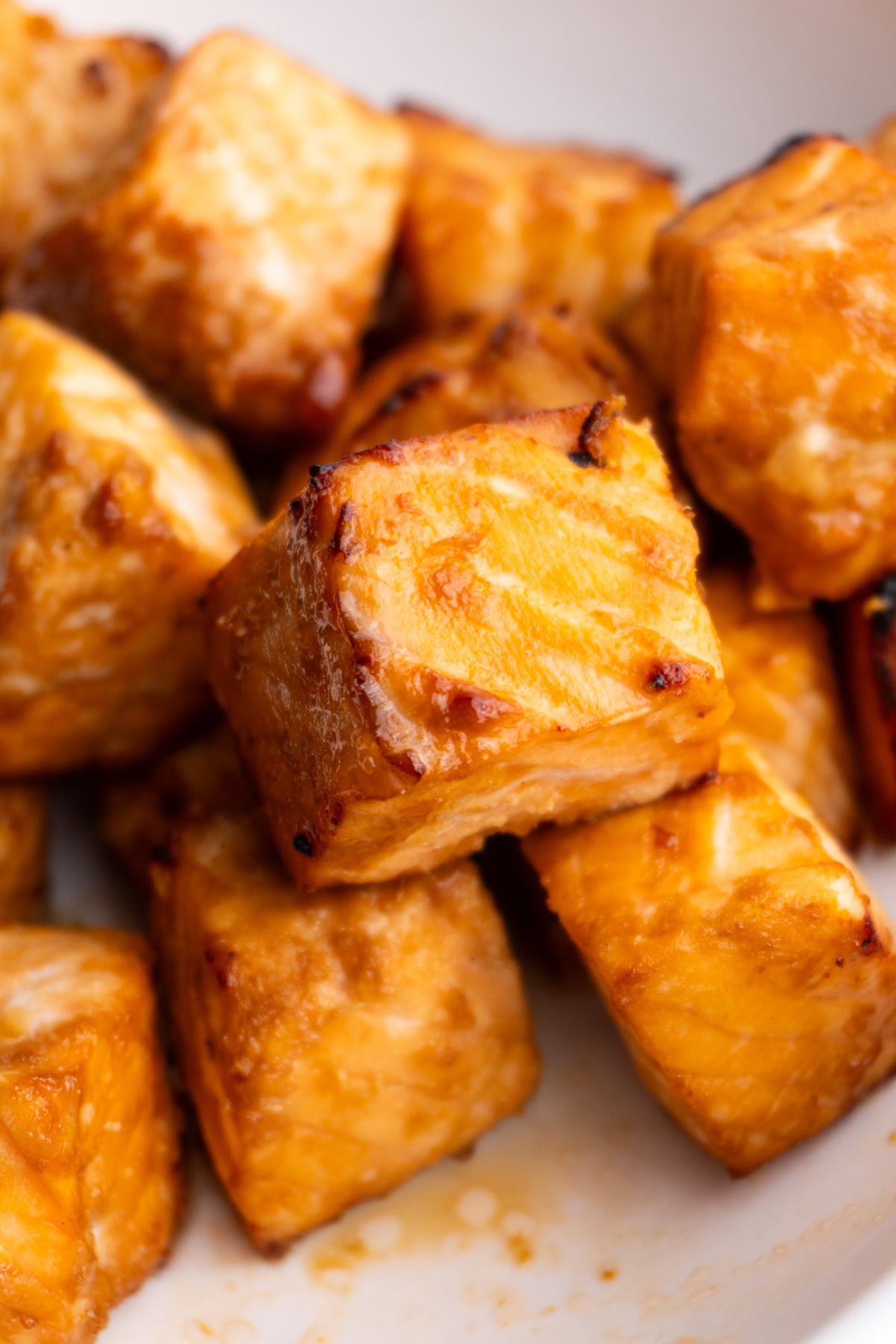 Air fryer salmon bite surrounded by other salmon bites.
