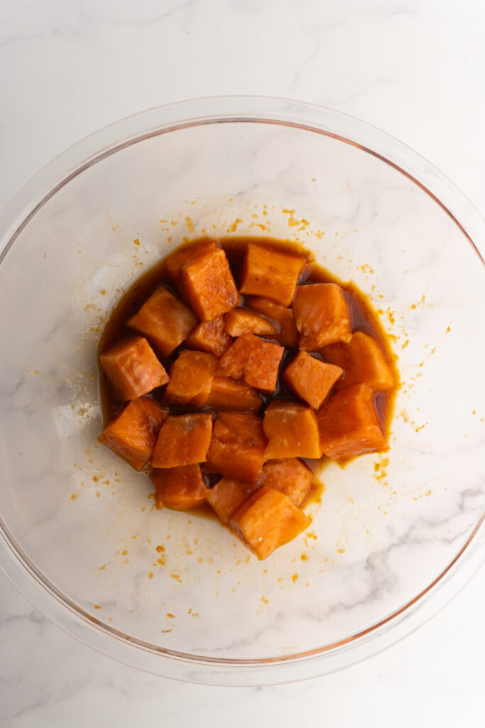 Diced salmon marinating in a glass bowl.