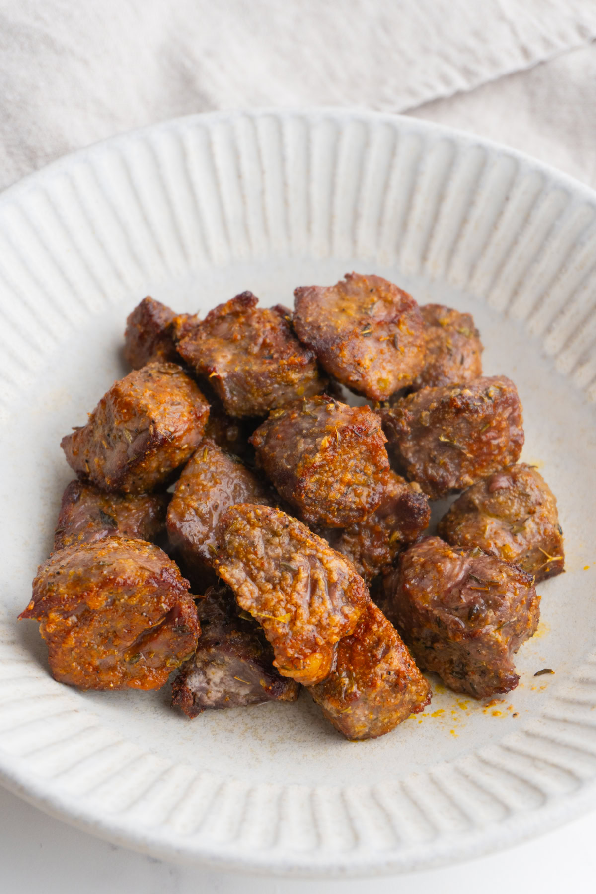 Juicy air fryer steak bites piled high in a bowl.