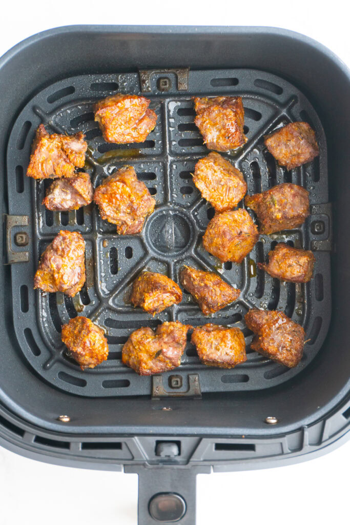 Finished steak bites in the air fryer basket.