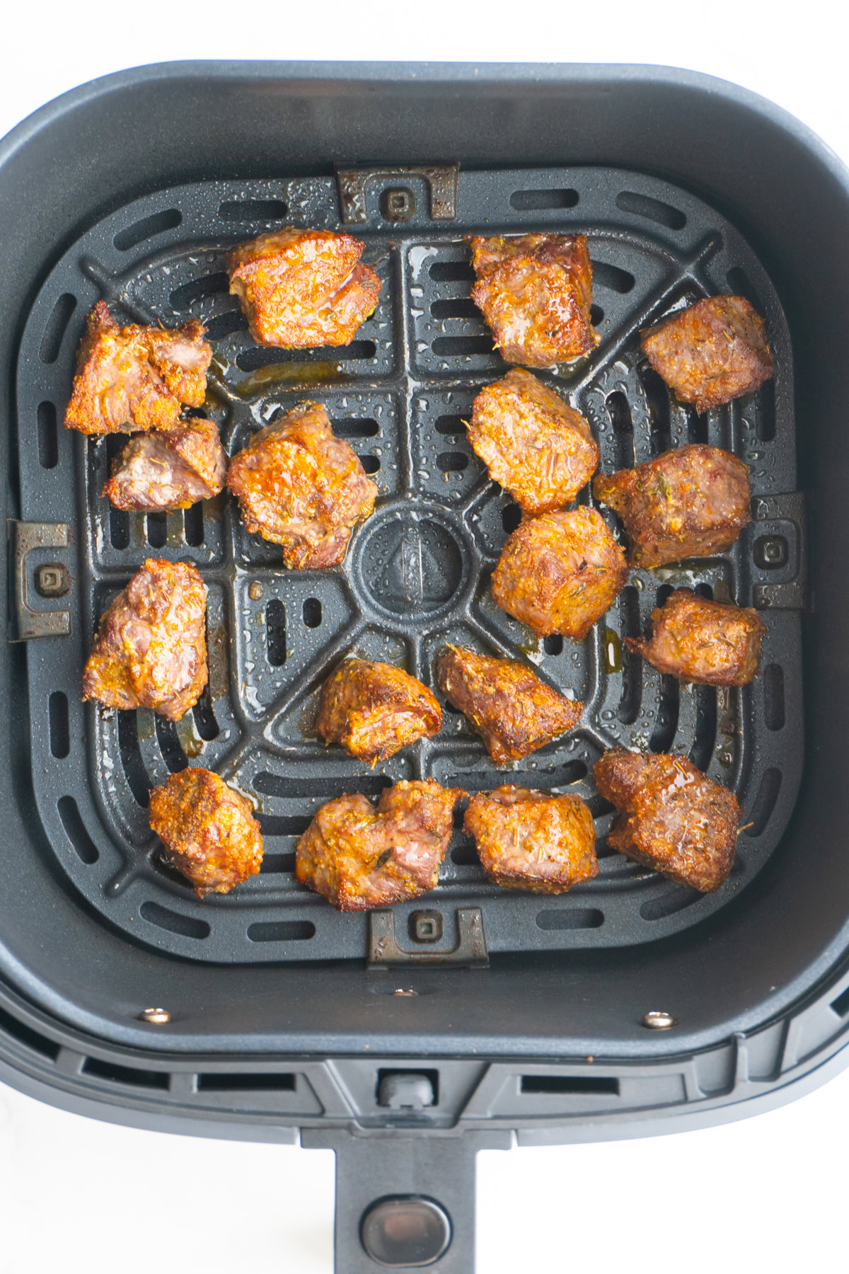 Finished steak bites in the air fryer basket.