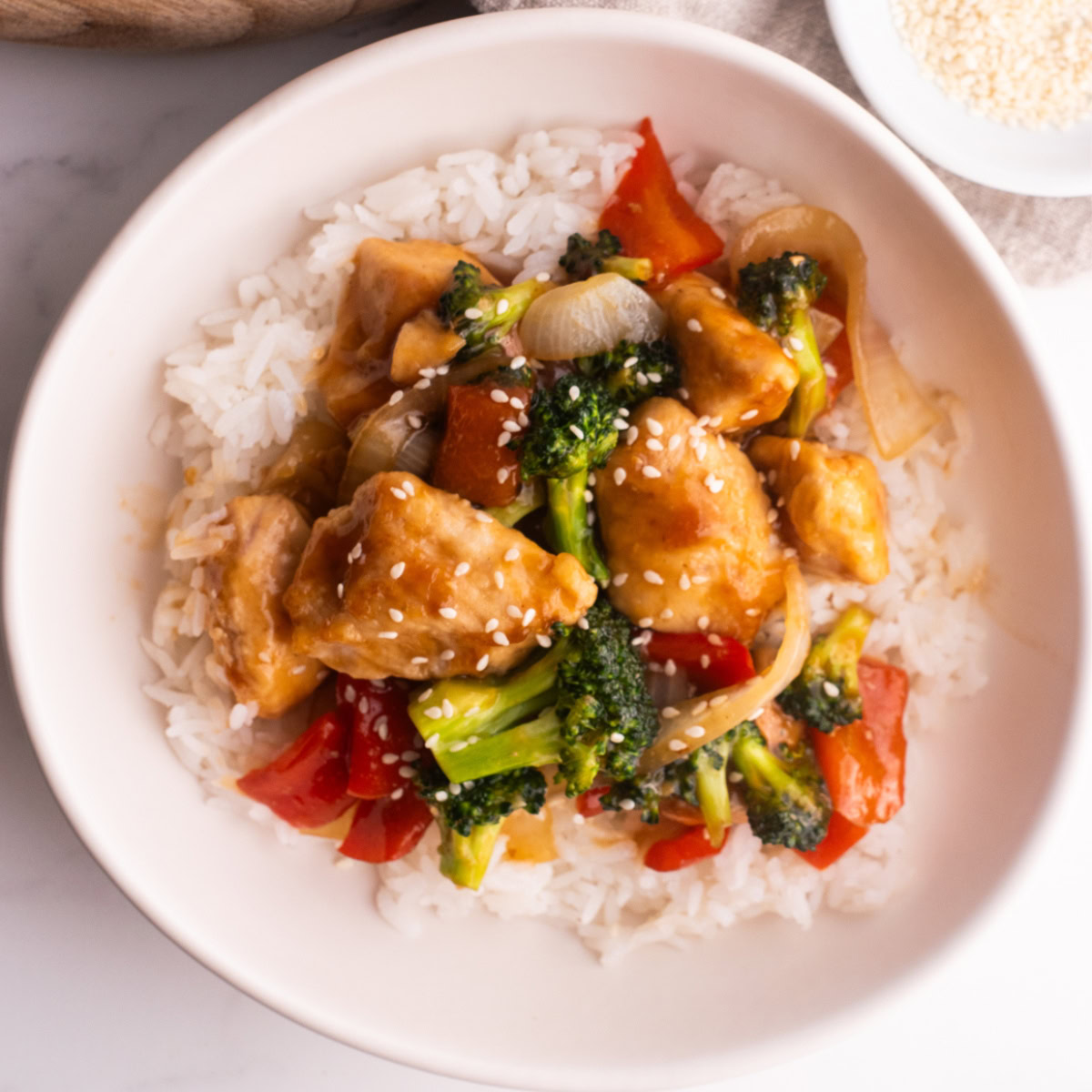 Chicken teriyaki bowl with rice and veggies in a white bowl.