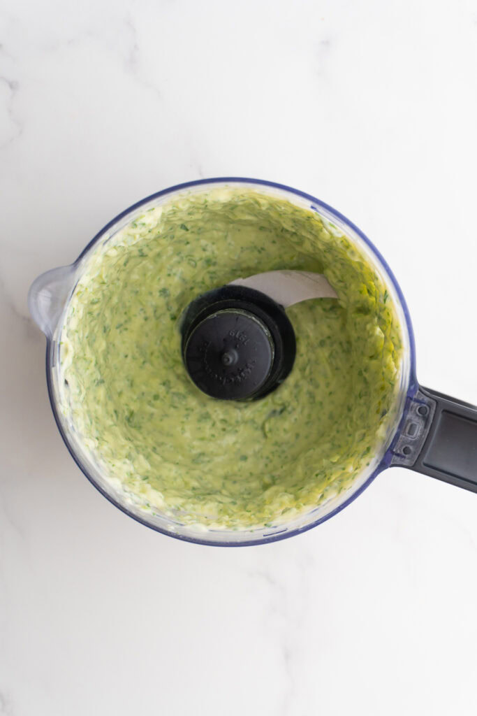 Cilantro lime sauce in a food processor after being blended.