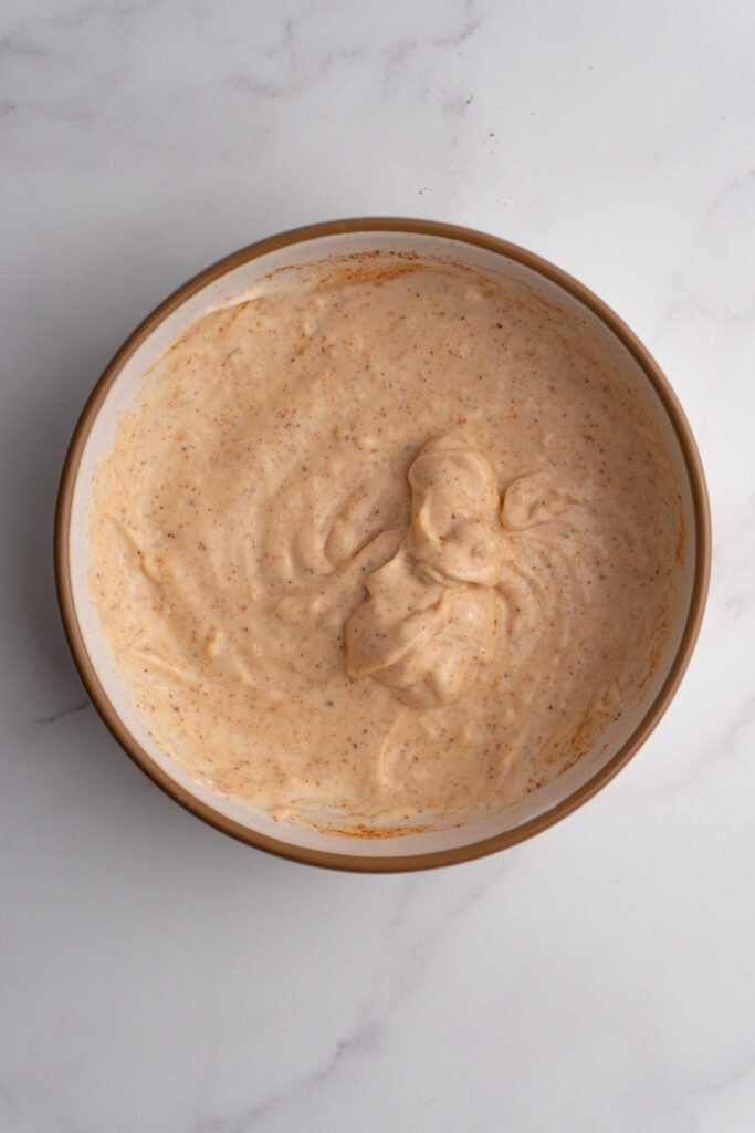 Mayo with spices and garlic in a bowl after being whisked together.