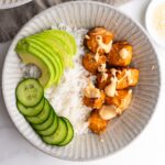 Air fryer salmon bowls with cucumber, avocado and spicy mayo on top.