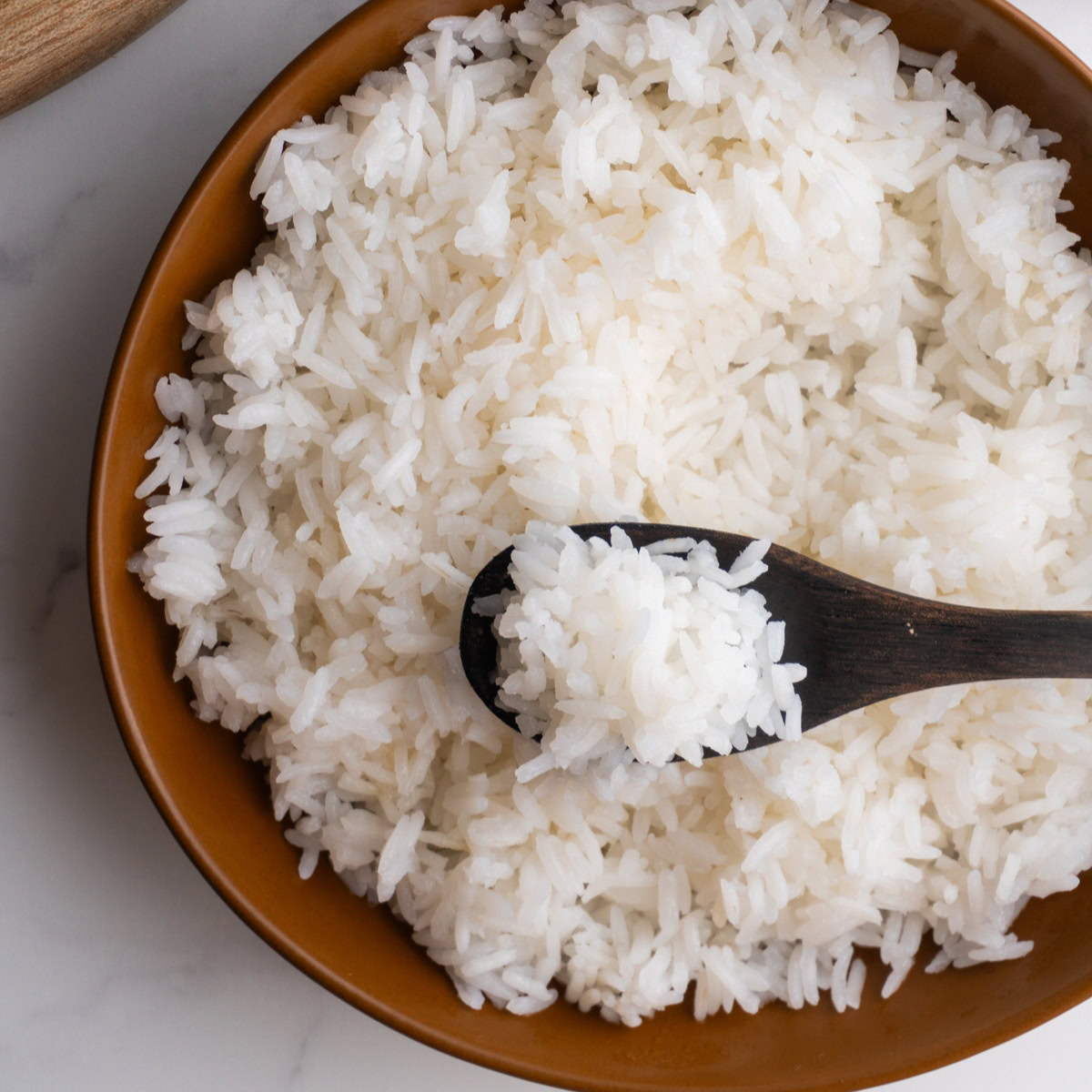 White rice in a bowl with a spoon.
