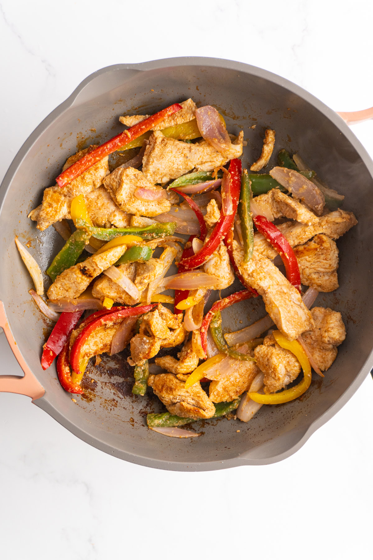 Finished chicken fajitas in a skillet.