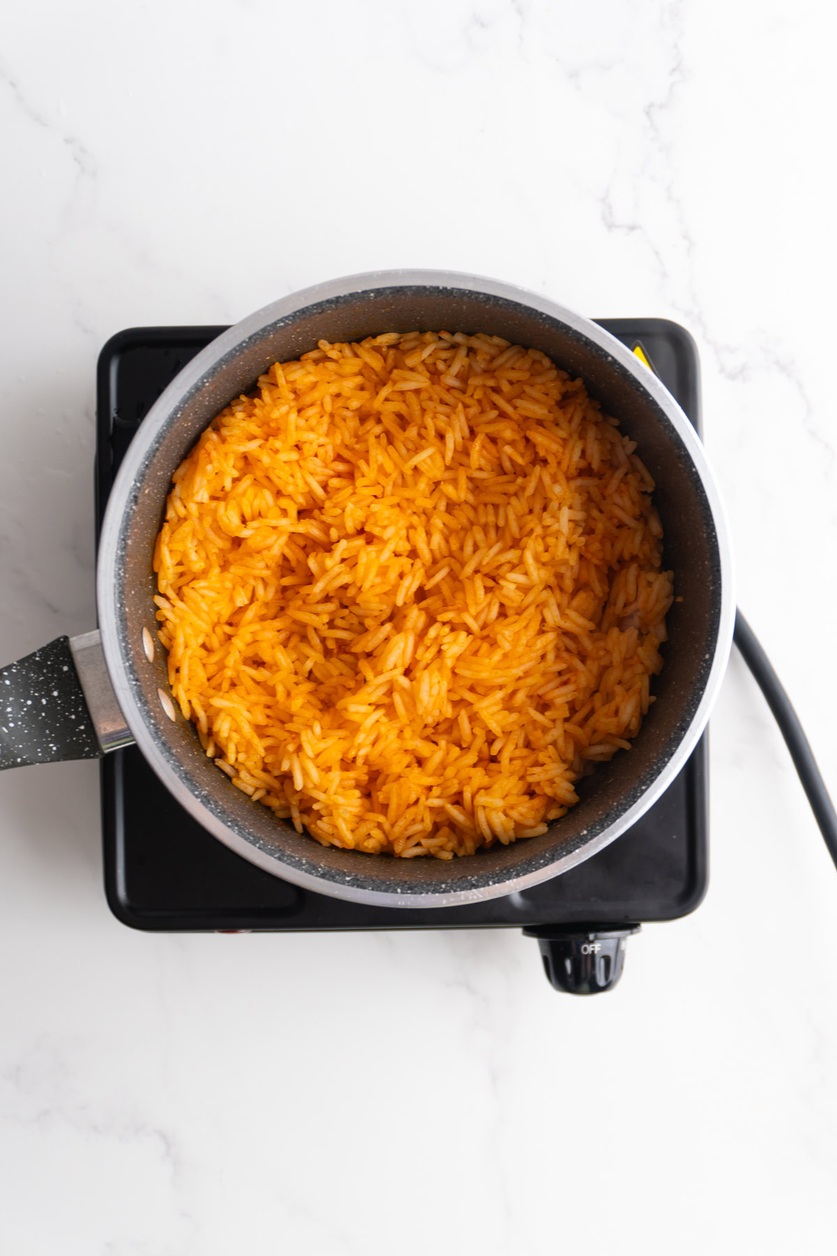 Fluffed Mexican rice in a sauce pan.