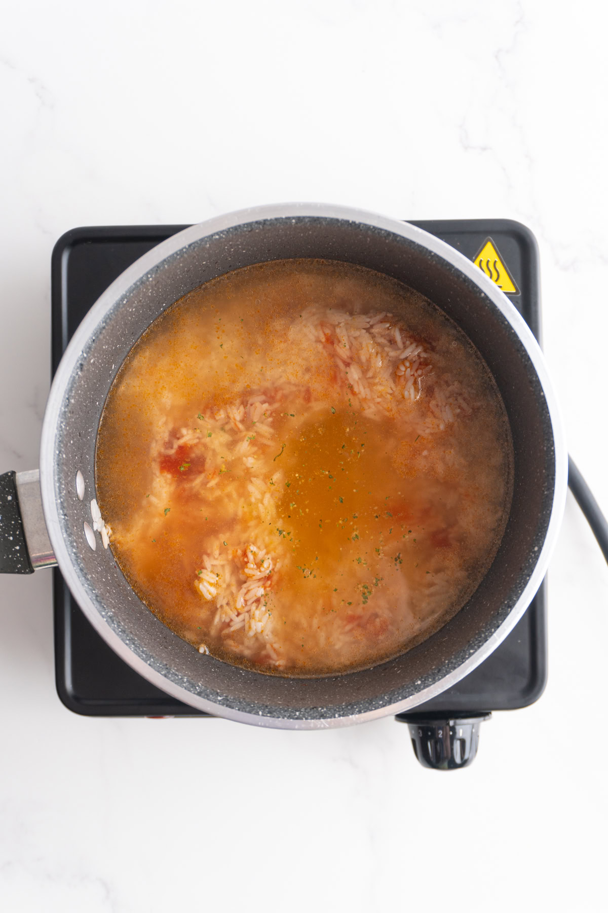 Water and chicken bouillon added to the saucepan.