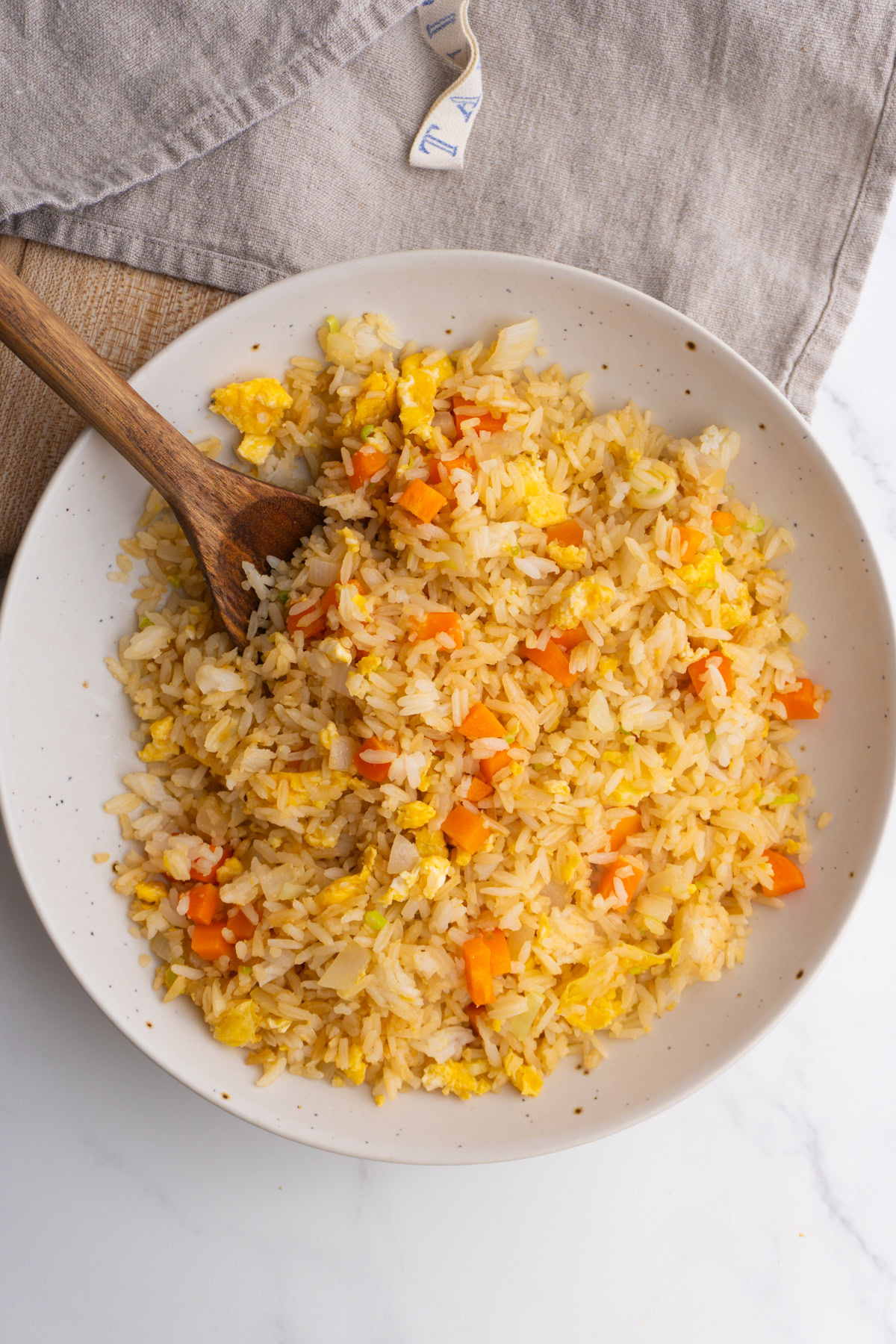 Hibachi fried rice served in a bowl with a wooden spoon.