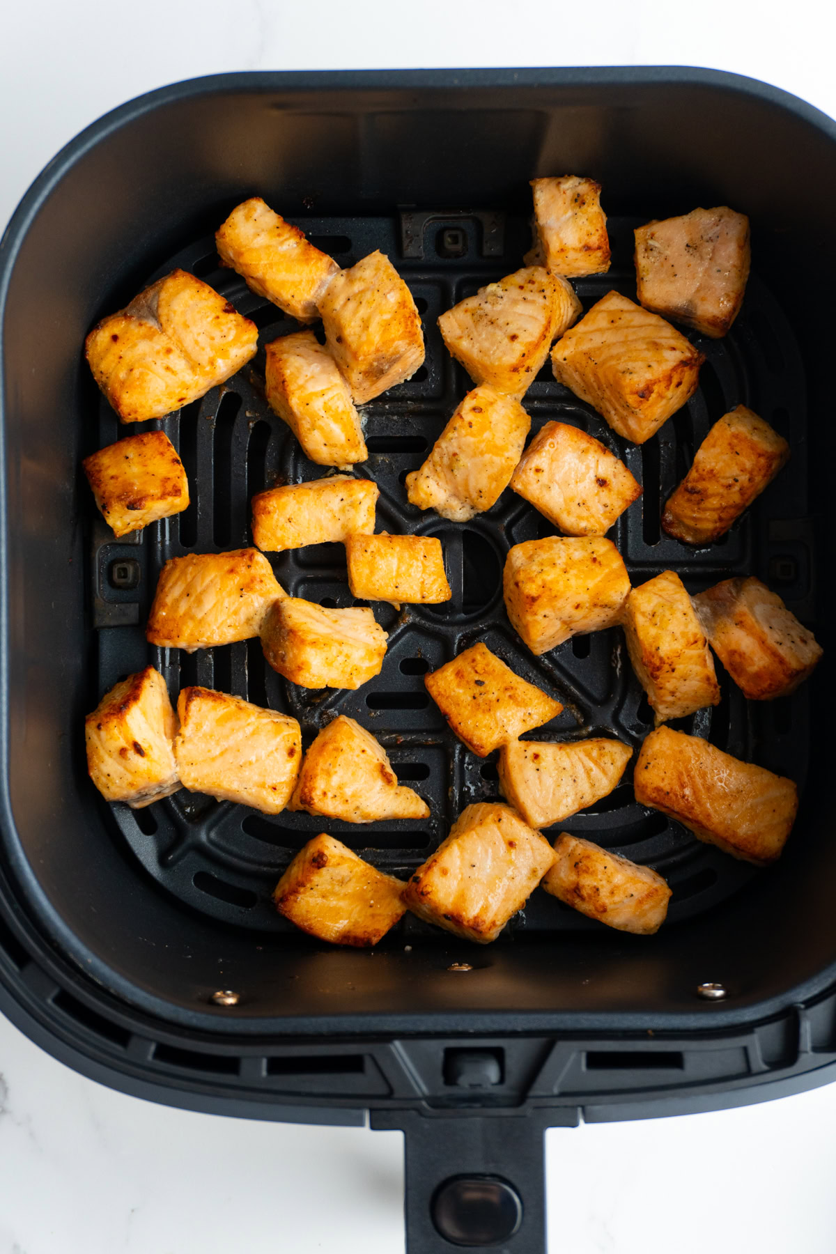 Salmon in the air fryer basket after cooking.
