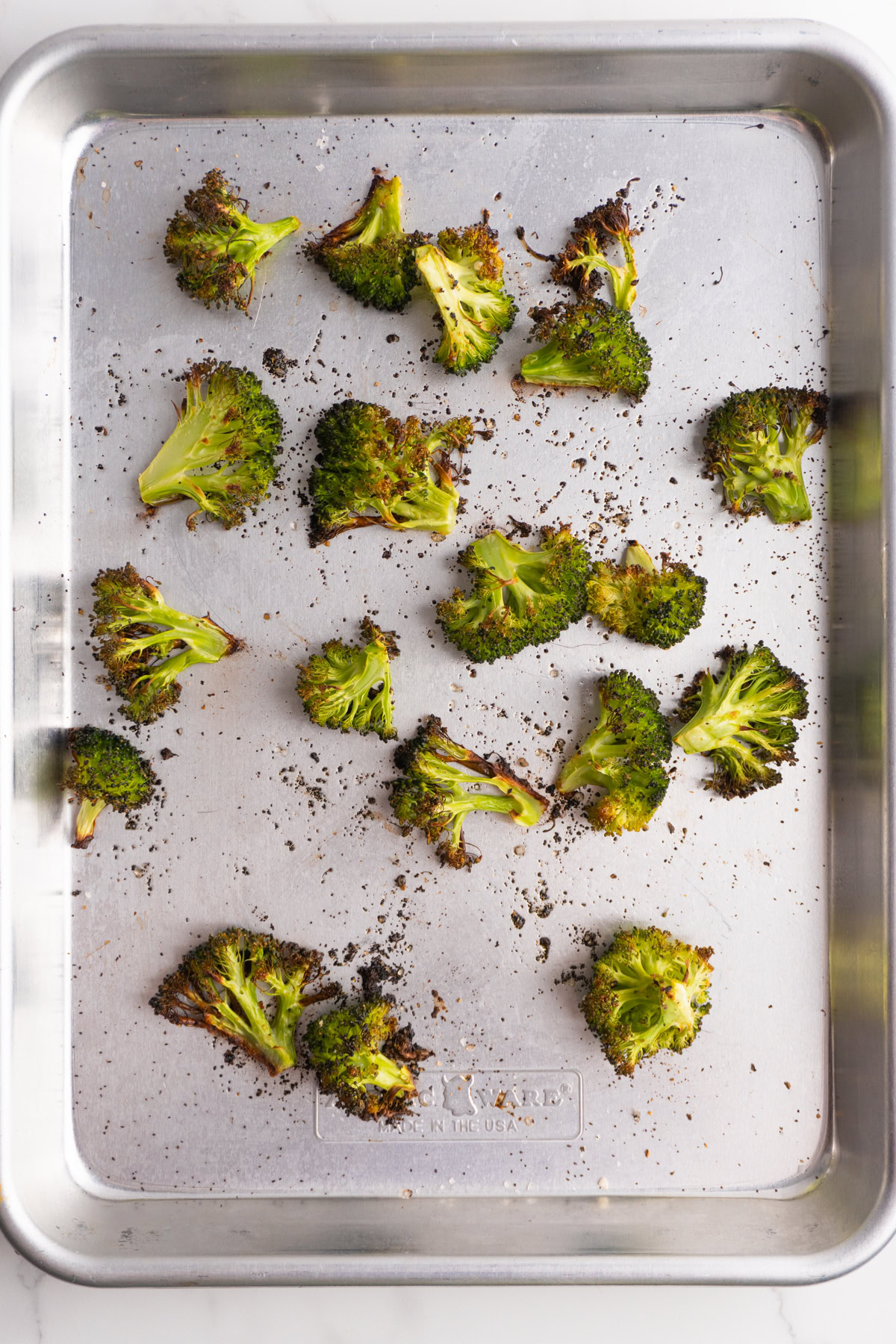 Roasted broccoli on a sheet pan.