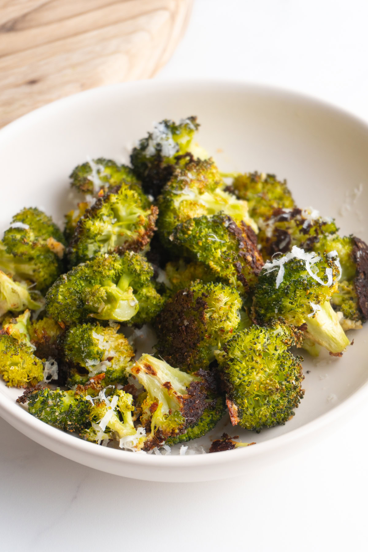 Parmesan broccoli served in a white bowl.