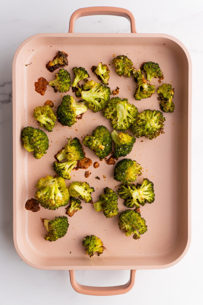 Parmesan broccoli on a pink sheet pan.