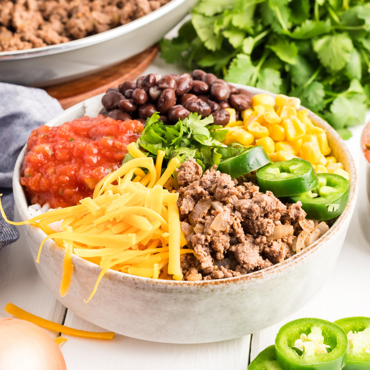Taco bowl with ground beef, cheese, corn, beans and salsa.