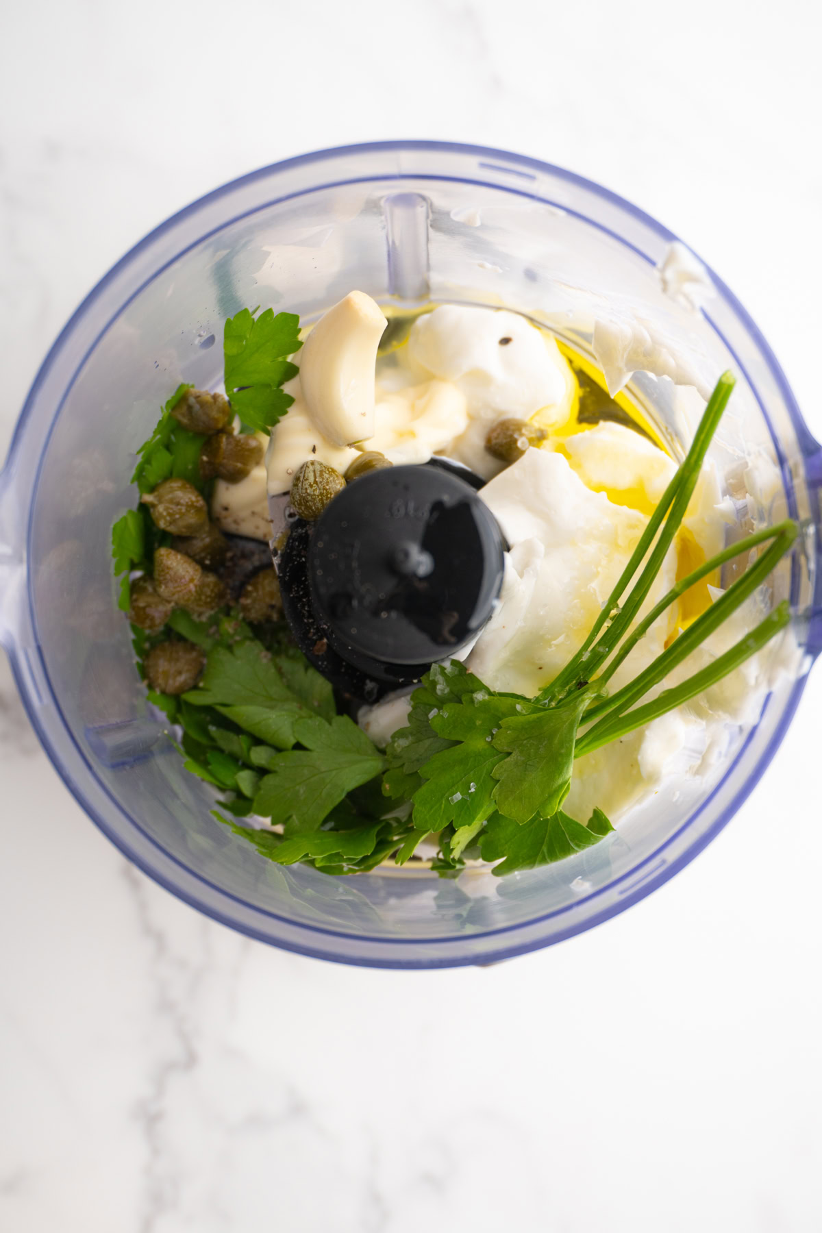 Ingredients for green goddess dip in a food processor before being blended.