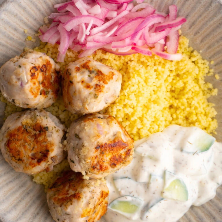 Mediterranean meatball bowl with couscous, tzatziki and pickled red onions.