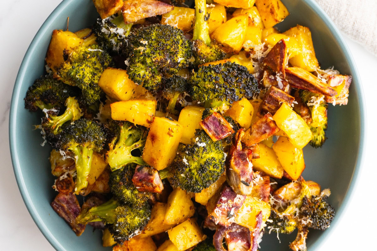 Close up shot of sheet pan roasted vegetables with parmesan in a bowl.