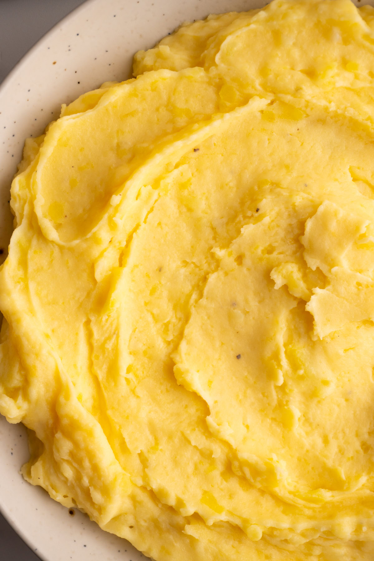Close up of cheesy mashed potatoes served in a bowl.