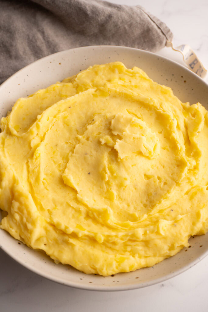 Mashed potatoes served in a large serving bowl.