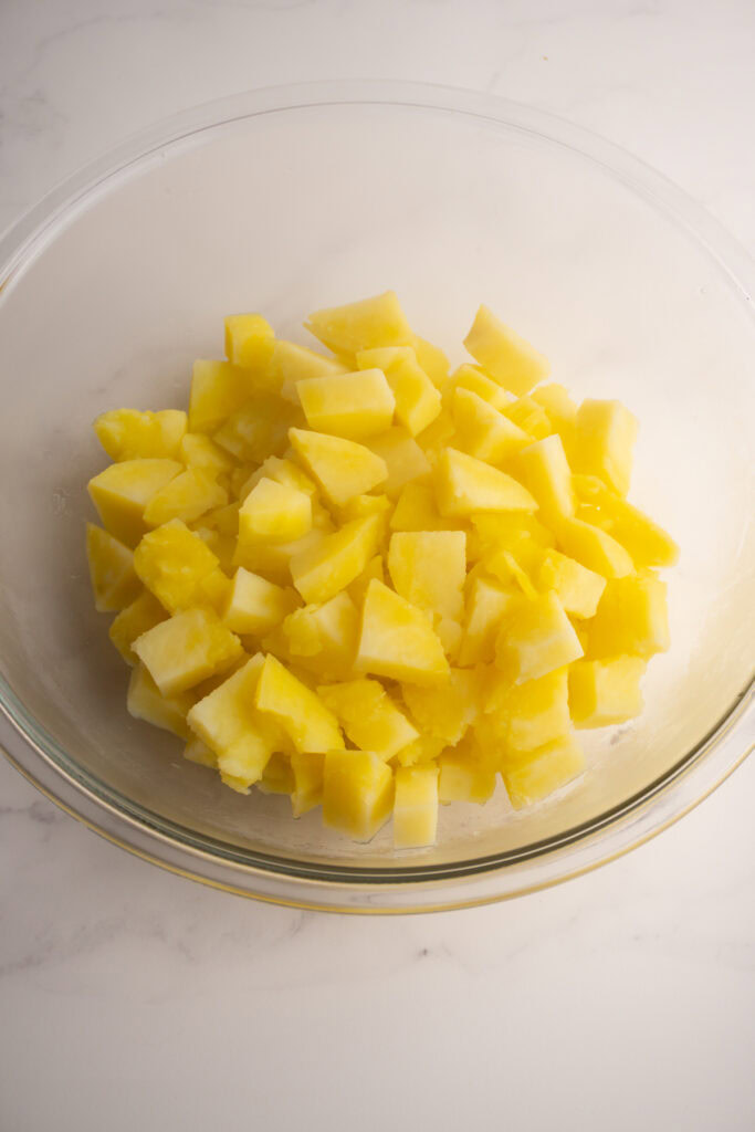 Cooked potatoes placed in a large mixing bowl.