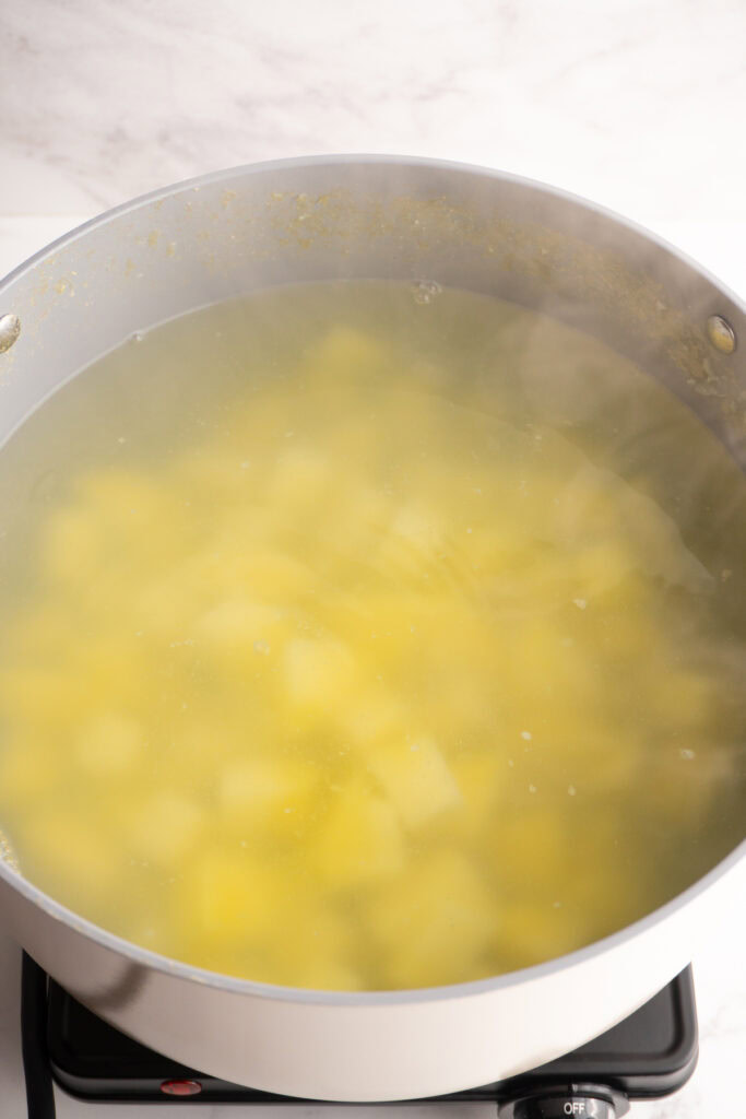 Potatoes boiling in a bit pot of water.