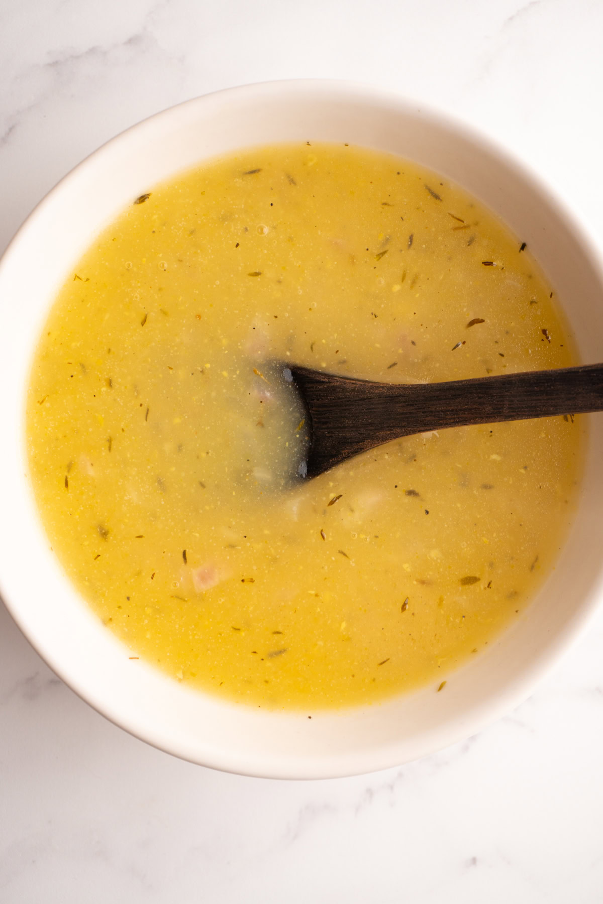 Overhead shot of finished chicken stock gravy with a bowl with a spoon.