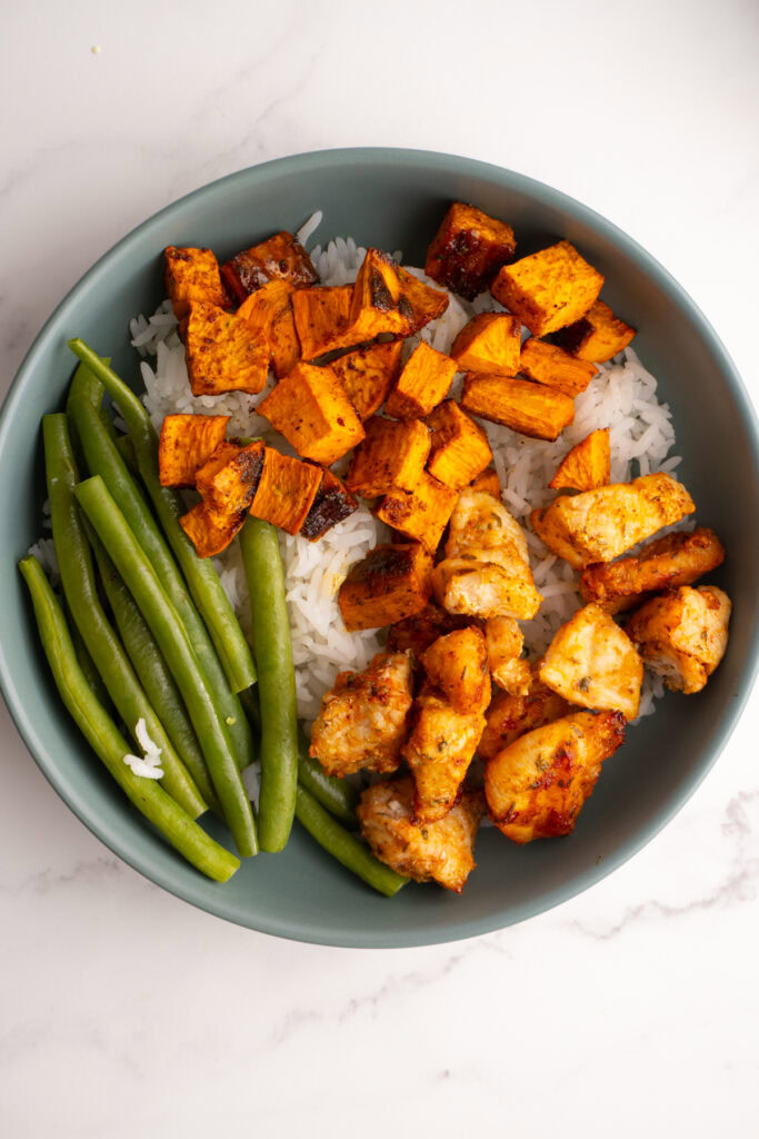 Bowl with rice, chicken, sweet potatoes and green beans.