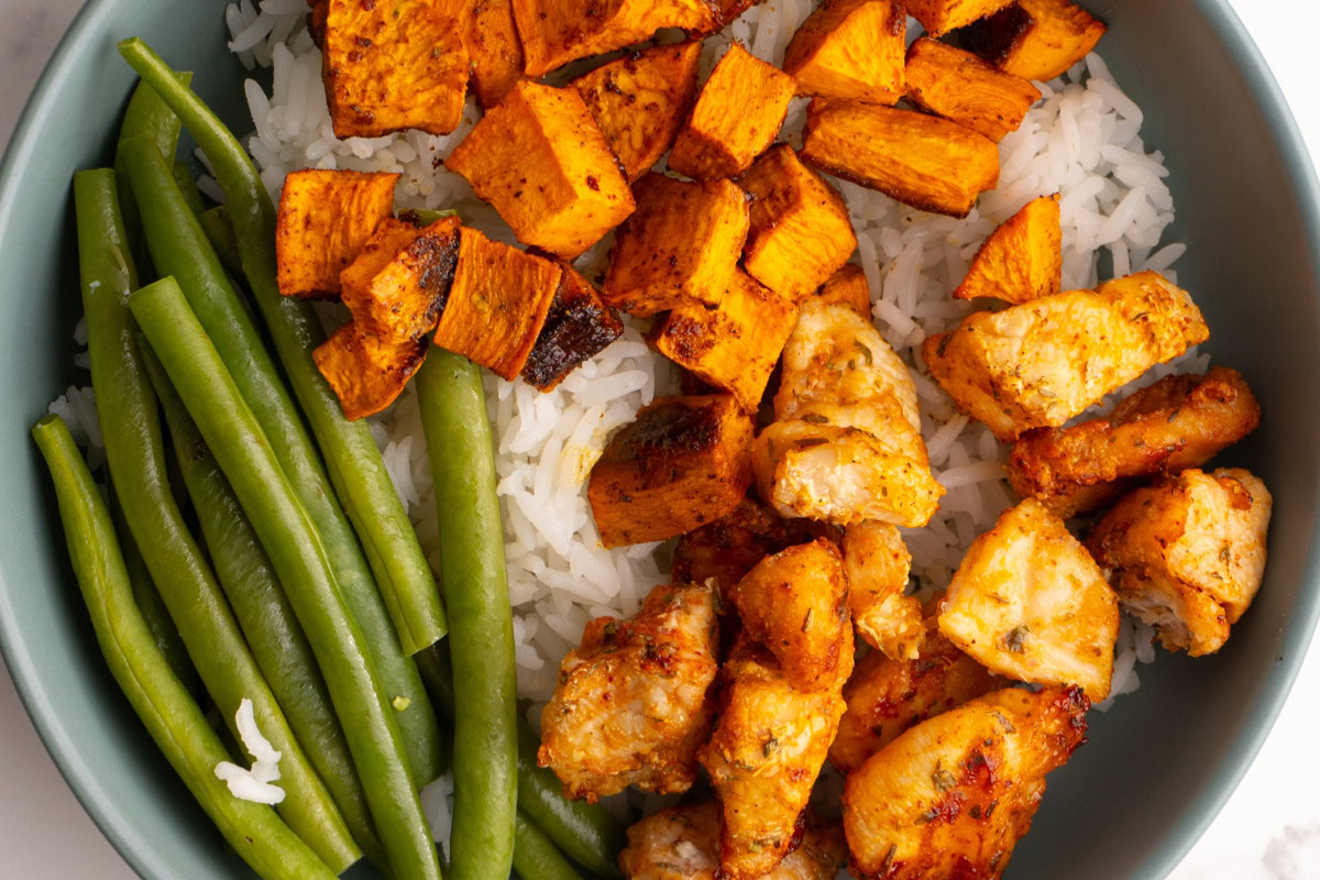 Close up shot of a chicken sweet potato bowl with green beans.
