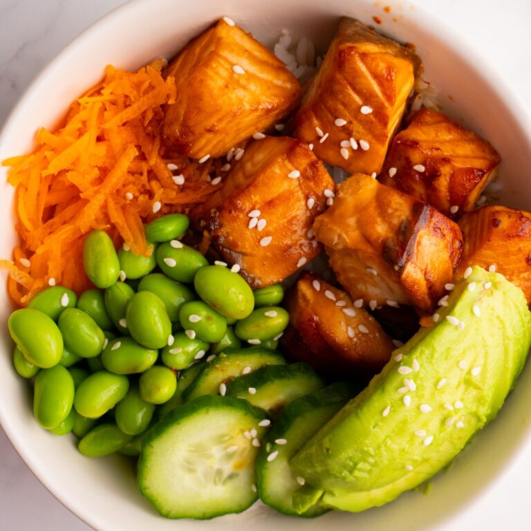 Finished cooked salmon poke bowl garnished with sesame seeds.