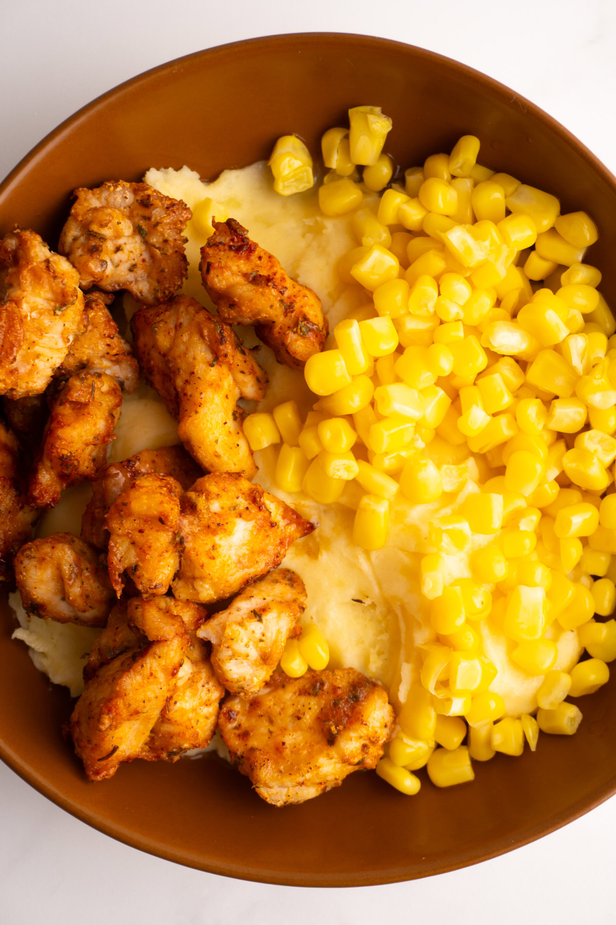 Chicken mashed potato bowl served in a brown bowl with gravy on top.