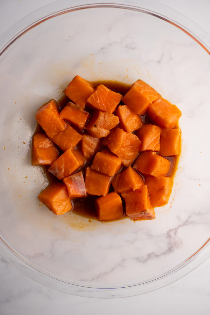 Marinating salmon in poke bowl sauce.