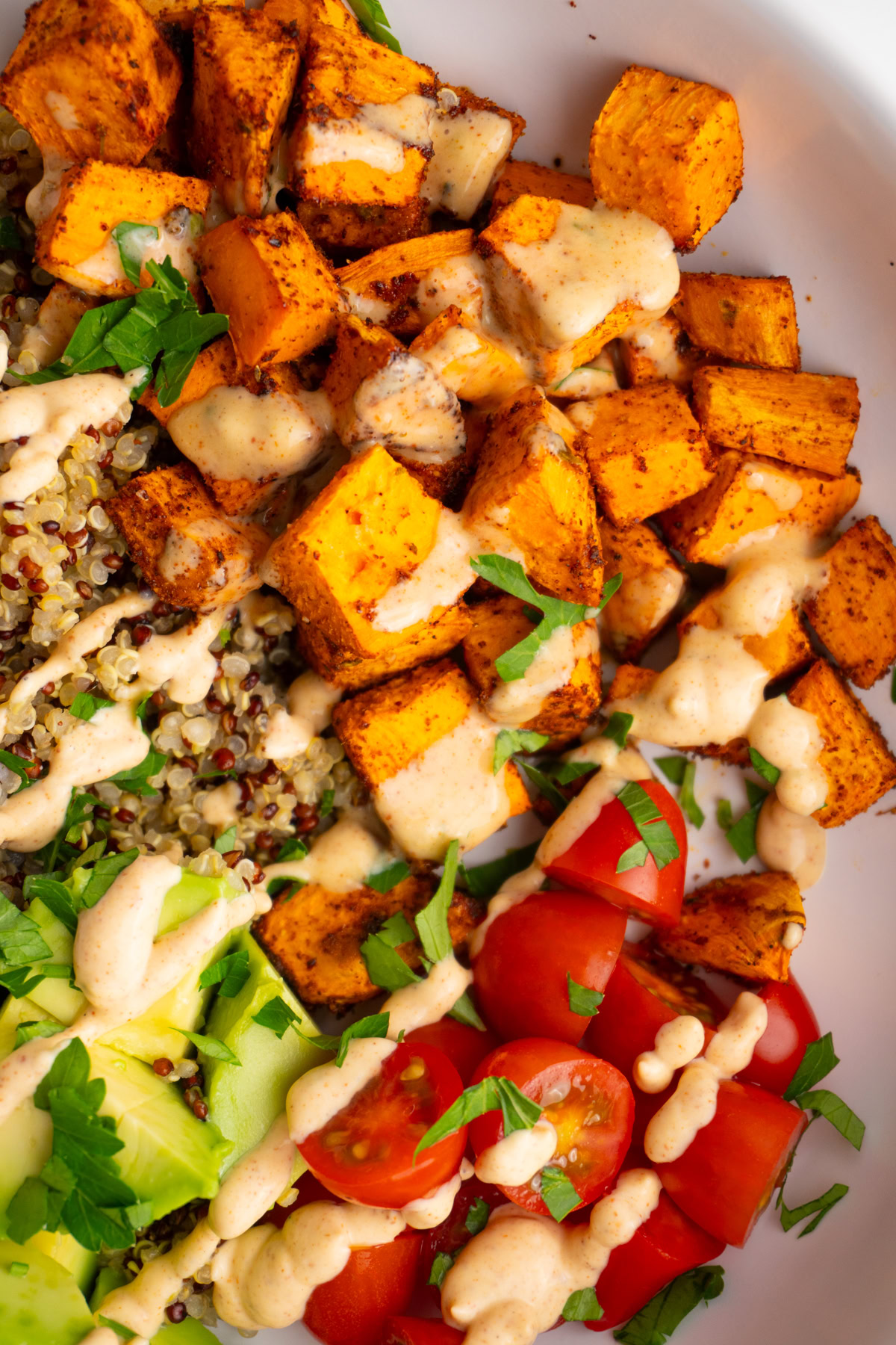 Close up of roasted sweet potatoes in a sweet potato taco bowl with taco sauce on top.