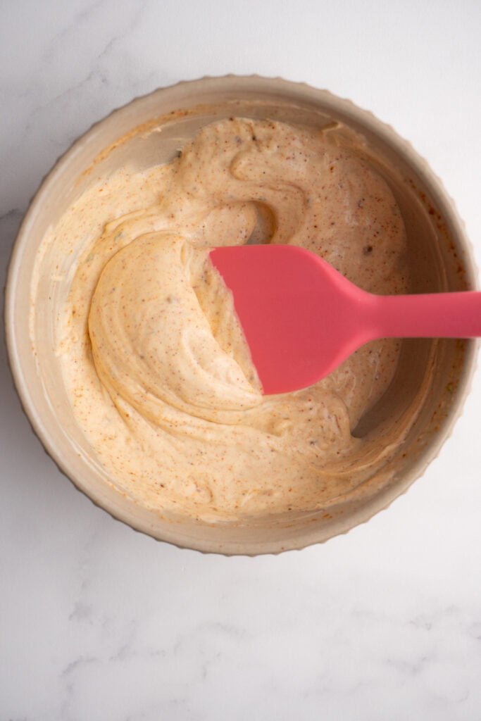 Taco sauce in a bowl with a small rubber spatula.